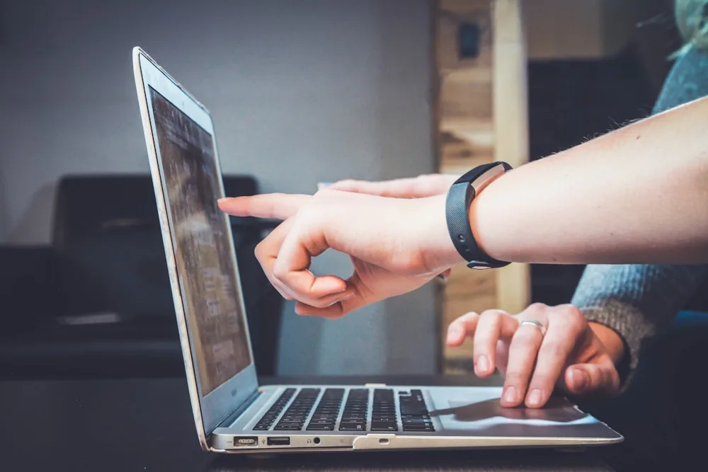 Illustrative photograph of people working together at a laptop